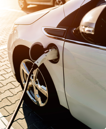 Nowoczesny biały samochód podłączony do stacji ładowania samochodów elektrycznych